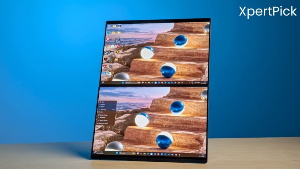 ASUS ZenBook Duo laptop shown in a vertical dual-screen configuration on a wooden desk, with both displays active and running Windows. (Source: Yetnesh Dubey / XpertPick)