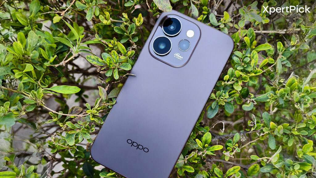 Oppo Reno15 Pro Mini back panel shown in horizontal orientation highlighting triple camera module and matte rear finish placed on foliage (Source: Yetnesh Dubey / XpertPick)